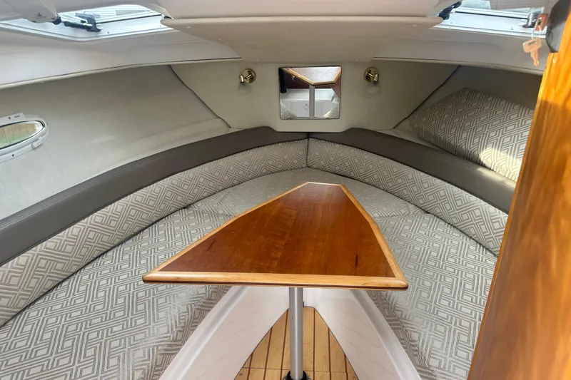 Slide: The Image of 2017 Cutwater C24 cabin interior with patterned cushions and wooden table. - 12