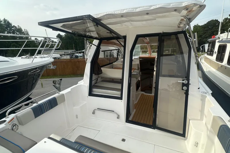 Slide: The Image of 2017 Cutwater C24 boat interior with open cabin doors, showcasing seating and deck area. - 4
