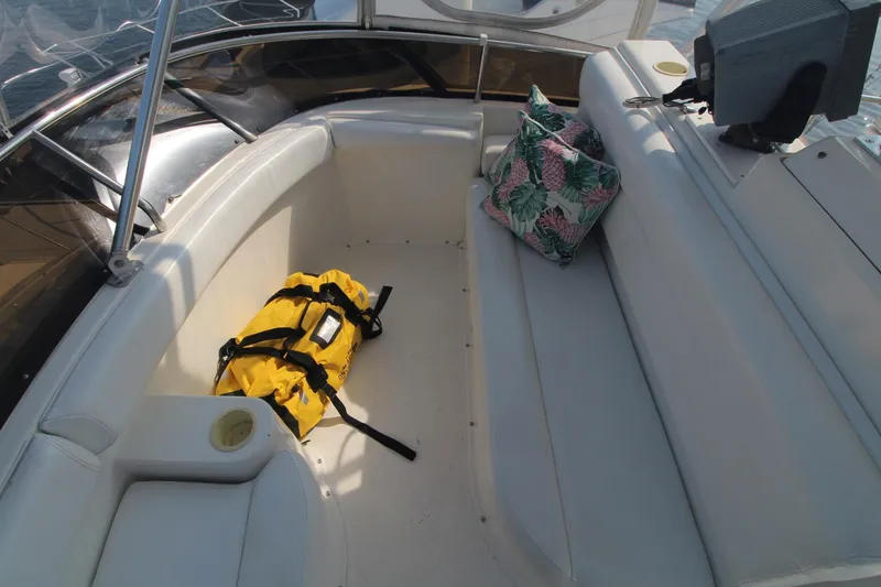 Slide: The Image of 1996 Silverton 41 Convertible boat interior with seating, yellow bag, and floral pillow. - 11