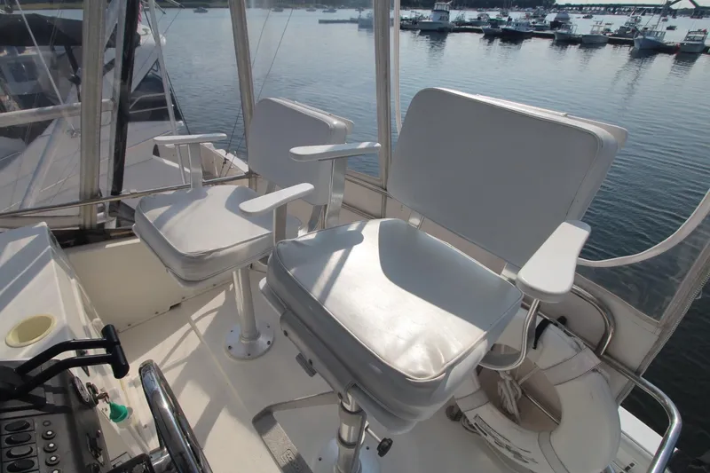 Slide: The Image of 1996 Silverton 41 Convertible boat helm with white captain chairs overlooking marina. - 18
