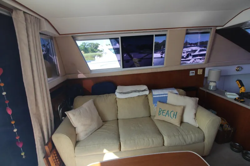 Slide: The Image of Interior of 1996 Silverton 41 Convertible yacht with cozy beige sofa and nautical decor. - 24