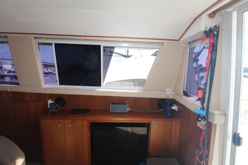 Slide: The Image of Interior of a 1996 Silverton 41 Convertible yacht with wooden cabinetry and windows. - 25