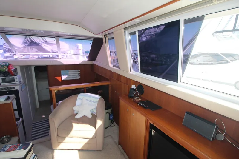 Slide: The Image of Interior of 1996 Silverton 41 Convertible yacht with cozy seating and large windows. - 27