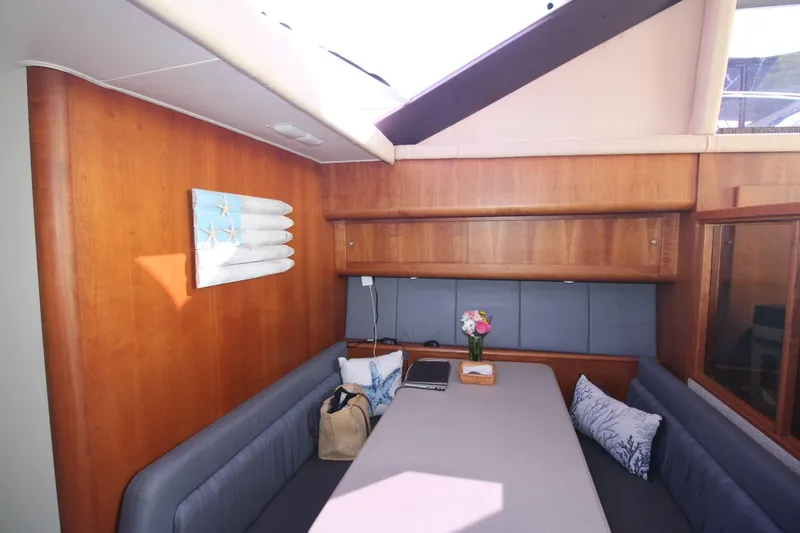Slide: The Image of Interior of 1996 Silverton 41 Convertible yacht with cozy seating and wooden accents. - 29
