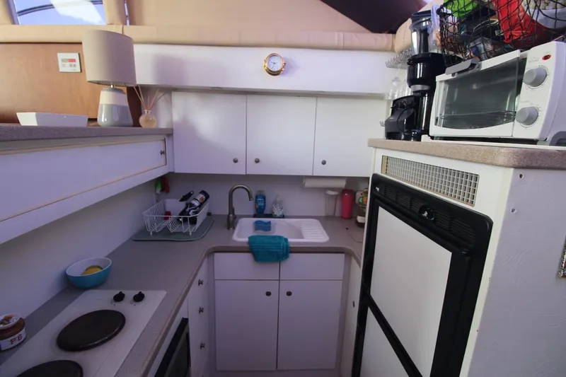 Slide: The Image of Compact kitchen in a 1996 Silverton 41 Convertible boat with appliances and storage. - 33
