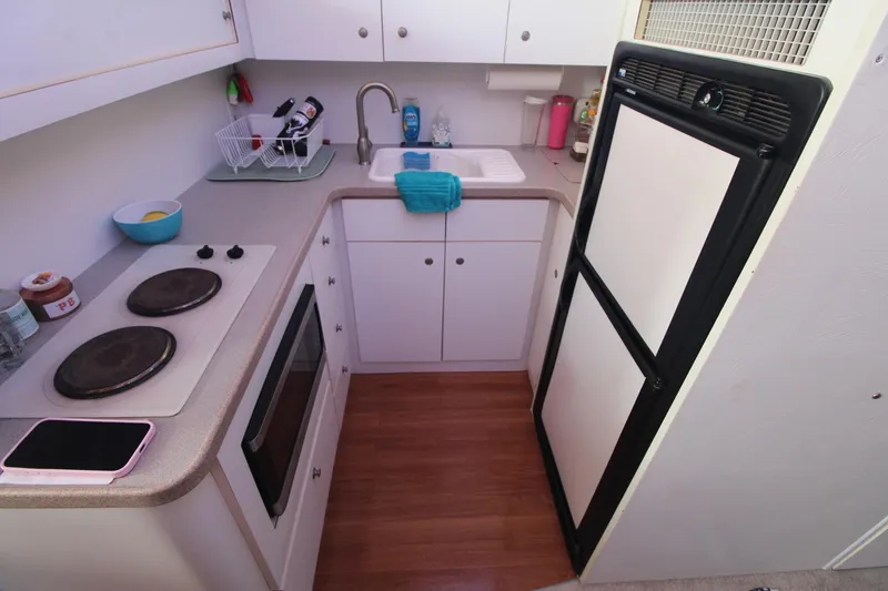 Slide: The Image of Compact kitchen in a 1996 Silverton 41 Convertible boat with stove, sink, and refrigerator. - 34