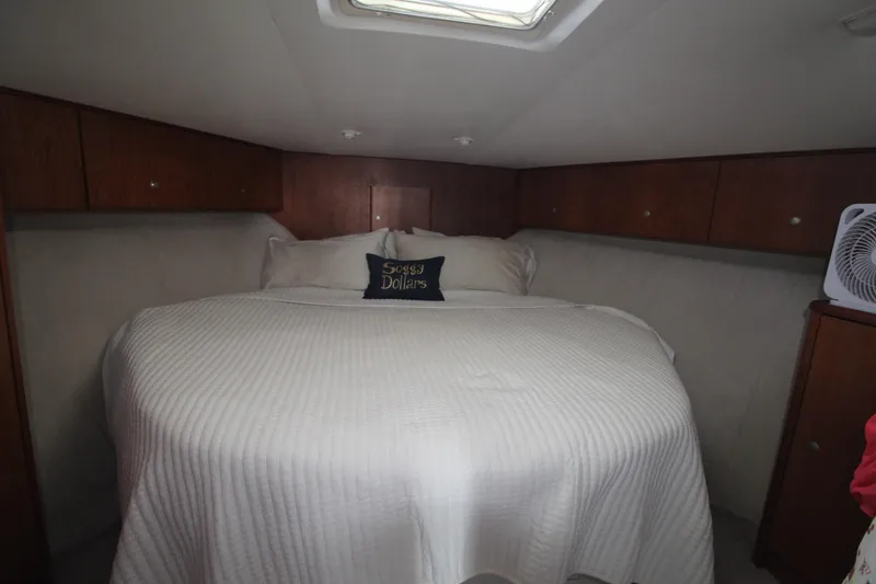 Slide: The Image of 1996 Silverton 41 Convertible cabin with cozy bed and wooden storage cabinets. - 38
