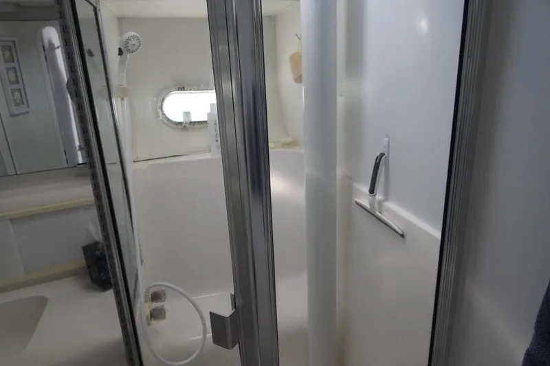 Slide: The Image of Bathroom interior of 1996 Silverton 41 Convertible yacht with shower and porthole window. - 44