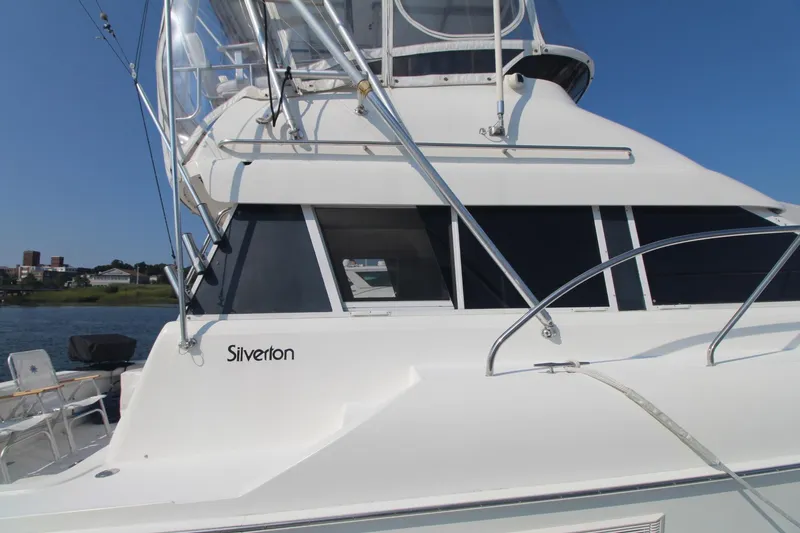 Slide: The Image of 1996 Silverton 41 Convertible yacht on water, showcasing sleek design and structure. - 5