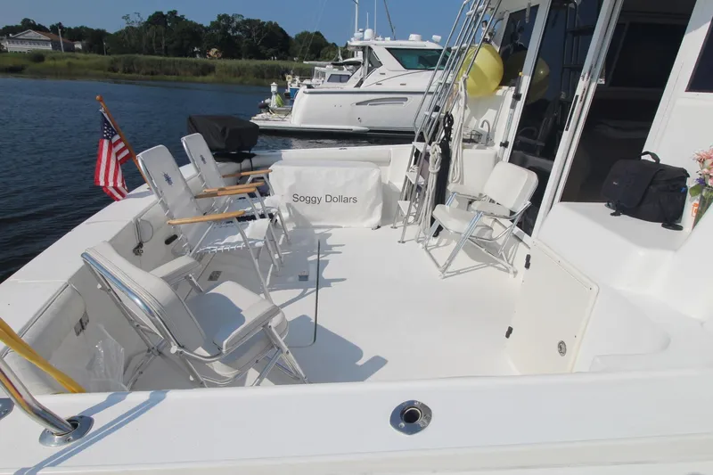 Slide: The Image of 1996 Silverton 41 Convertible yacht deck with chairs and American flag. - 7