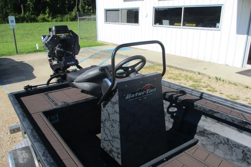 Slide: The Image of 2026 Gator Tail 2054 EXTREME CC boat with steering console and motor, parked outside. - 10