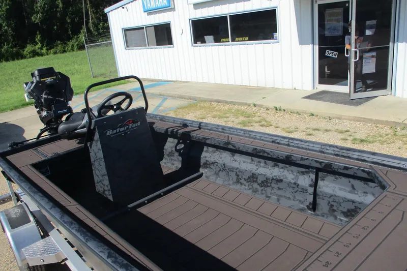 Slide: The Image of 2026 Gator Tail 2054 EXTREME CC boat outside dealership, featuring open deck and steering console. - 9