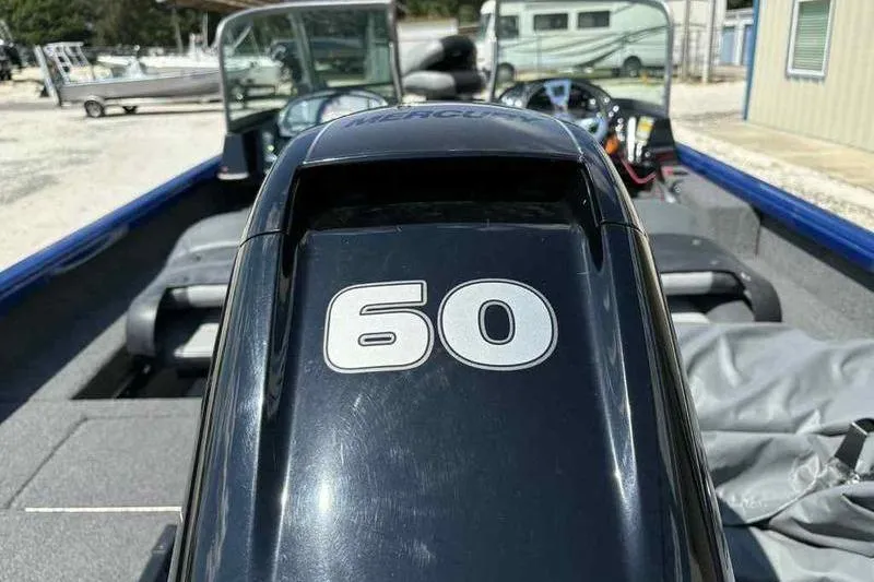 Slide: The Image of 2017 Triton 168 DV boat with Mercury 60 horsepower engine, parked outdoors. - 12