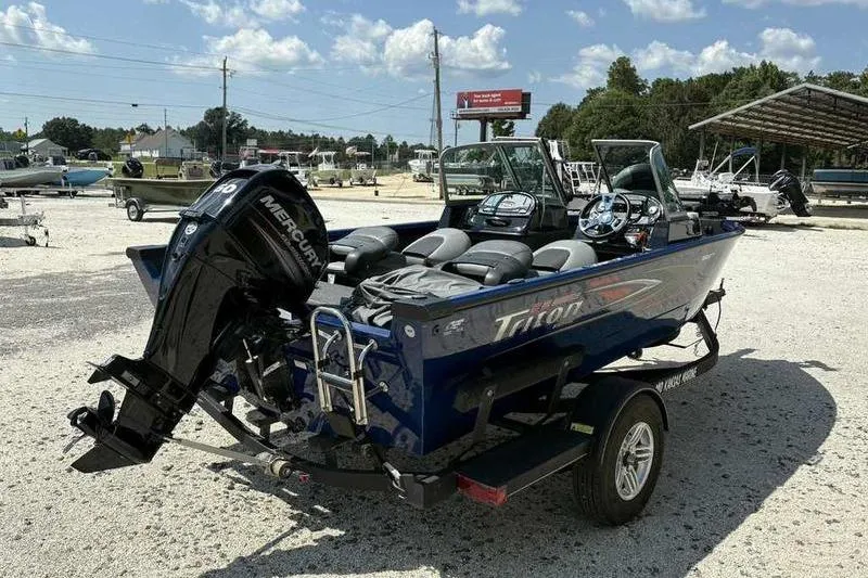 Slide: The Image of 2017 Triton 168 DV boat with Mercury engine on trailer in sunny outdoor setting. - 2