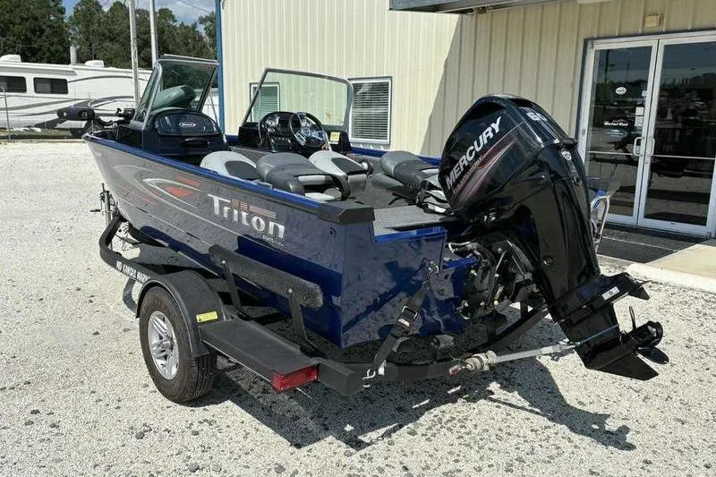 Slide: The Image of 2017 Triton 168 DV boat with Mercury engine on trailer, parked outside a building. - 4