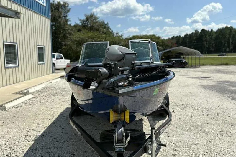 Slide: The Image of 2017 Triton 168 DV boat with Minn Kota motor on trailer, parked outdoors. - 5