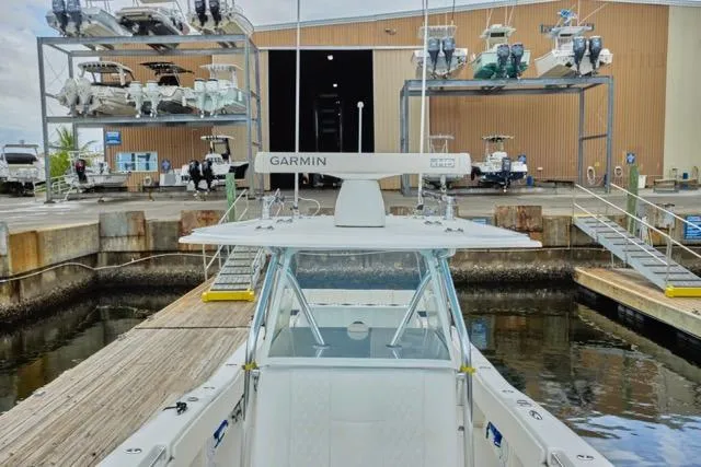 Slide: The Image of 2015 Invincible 36 boat deck, spacious seating, docked by calm water. - 10