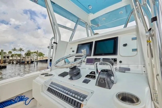 Slide: The Image of Triple Yamaha 300 V6 engines on a 2015 Invincible 36 boat docked by the water. - 2