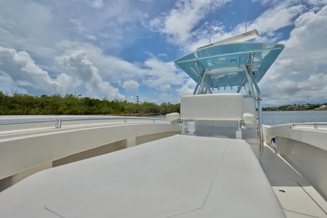 Slide: The Image of Invincible 36 boat, 2015 model, on calm water under a partly cloudy sky. - 24