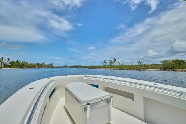 Slide: The Image of Invincible 36 boat cruising on a serene waterway under a clear blue sky, 2015 model. - 29