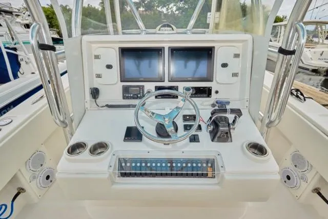 Slide: The Image of 2015 Invincible 36 boat dashboard with dual screens and steering wheel. - 3