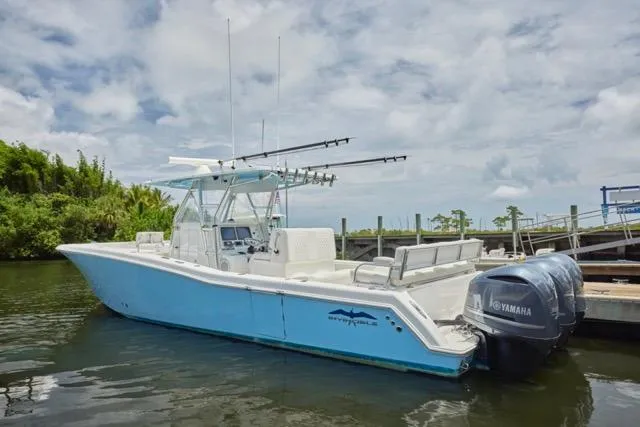 Slide: The Image of 2015 Invincible 36 boat dashboard with navigation screens and steering wheel on a sunny day. - 34