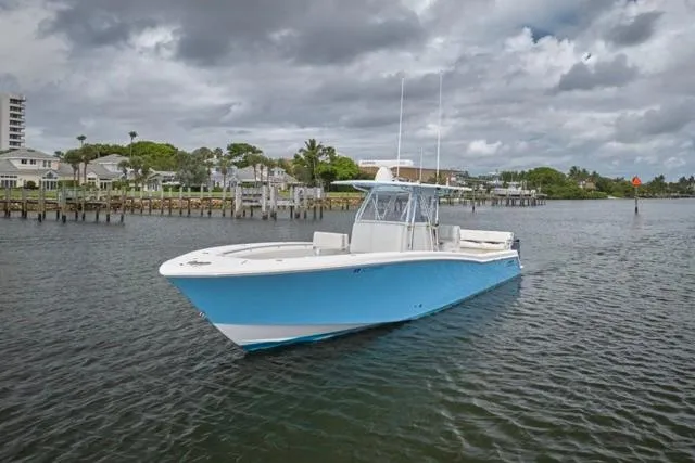Slide: The Image of 2015 Invincible 36 boat on calm water under cloudy sky. - 36
