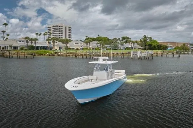 Slide: The Image of 2015 Invincible 36 boat on calm water under cloudy sky. - 37