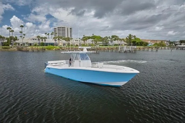 Slide: The Image of 2015 Invincible 36 boat on calm water near coastal homes and palm trees. - 39