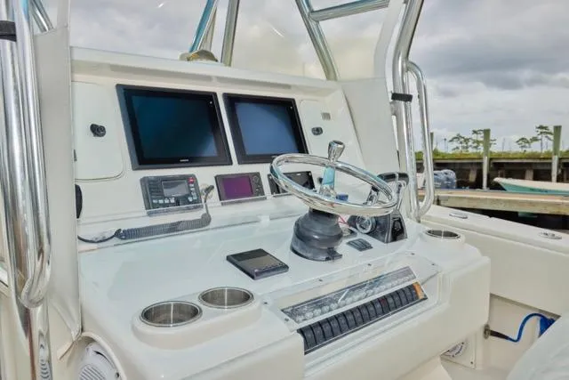 Slide: The Image of Control panel of a 2015 Invincible 36 boat with dual screens and steering wheel. - 4