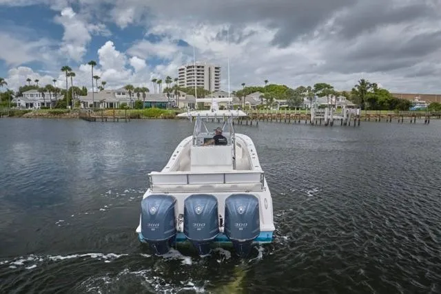 Slide: The Image of 2015 Invincible 36 boat with triple engines cruising on a scenic waterway. - 42