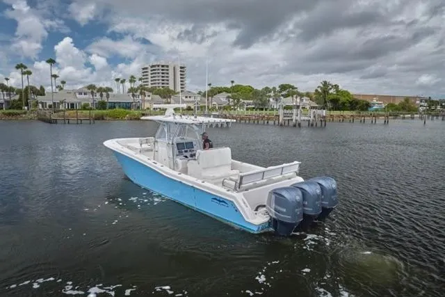 Slide: The Image of 2015 Invincible 36 boat with triple engines on a calm waterway. - 43