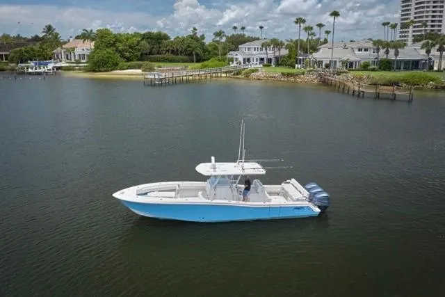Slide: The Image of 2015 Invincible 36 boat on calm water near waterfront homes. - 47