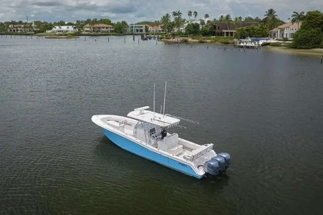 Slide: The Image of 2015 Invincible 36 boat on calm water near luxury waterfront homes. - 48