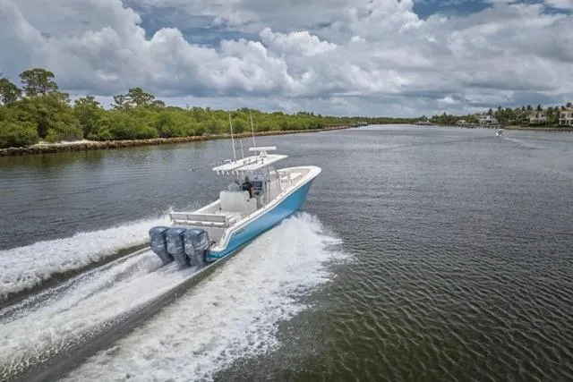 Slide: The Image of 2015 Invincible 36 boat cruising on a scenic river under cloudy skies. - 53