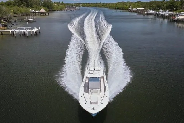 Slide: The Image of Invincible 36 boat cruising on a river, 2015 model, creating a wide wake. - 57