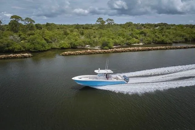 Slide: The Image of Invincible 36 boat cruising on a river, 2015 model, surrounded by lush greenery. - 69