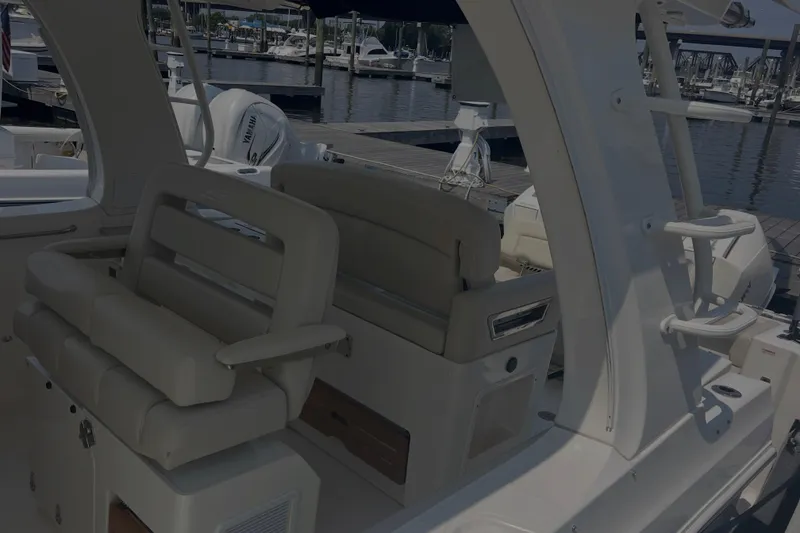 Slide: The Image of 2020 Boston Whaler 350 Realm interior with luxurious seating at marina. - 12