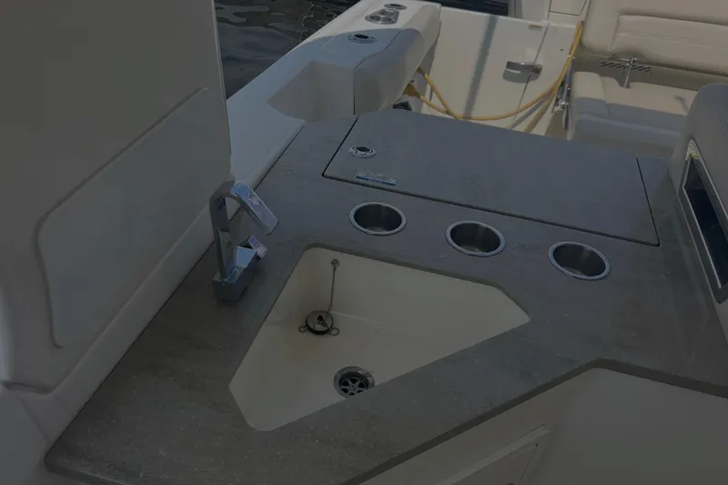 Slide: The Image of 2020 Boston Whaler 350 Realm boat interior with sink and cup holders. - 19