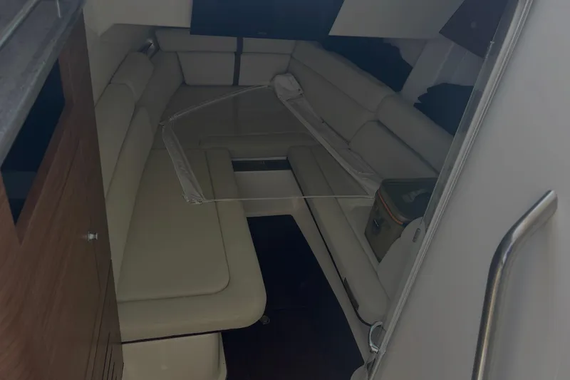 Slide: The Image of 2020 Boston Whaler 350 Realm cabin interior with beige seating and wooden cabinetry. - 27