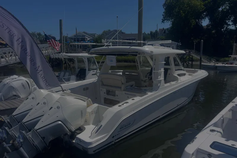 Slide: The Image of 2020 Boston Whaler 350 Realm boat docked at a marina with triple engines. - 30