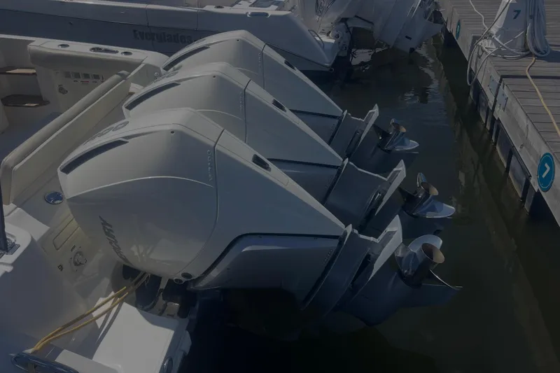 Slide: The Image of Triple outboard engines on a 2020 Boston Whaler 350 Realm docked at a marina. - 32