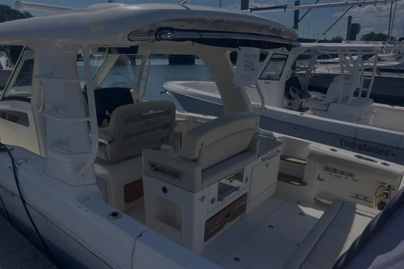 Slide: The Image of 2020 Boston Whaler 350 Realm boat interior at marina, showcasing seating and helm area. - 33