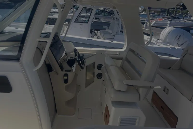 Slide: The Image of 2020 Boston Whaler 350 Realm interior with helm, seating, and dashboard. - 35
