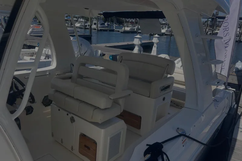 Slide: The Image of 2020 Boston Whaler 350 Realm interior with plush seating at a marina. - 36