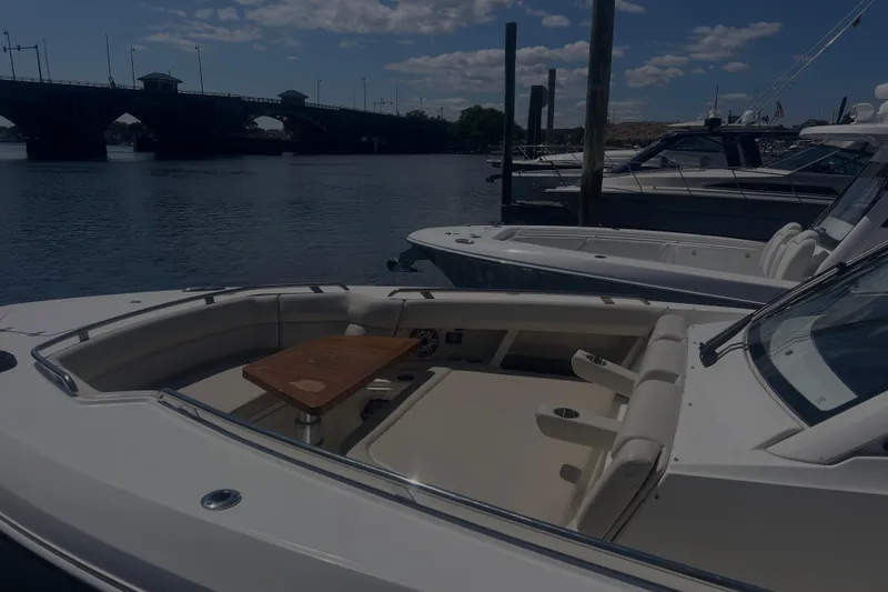 Slide: The Image of 2020 Boston Whaler 350 Realm docked near a bridge under a partly cloudy sky. - 37