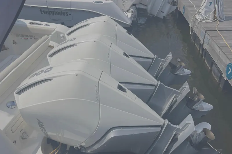 Slide: The Image of Triple outboard engines on a 2020 Boston Whaler 350 Realm docked at a marina. - 5