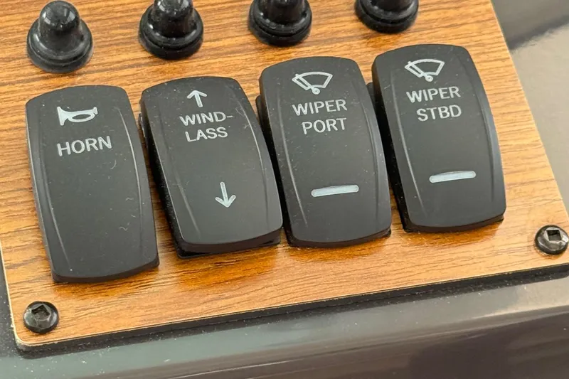 Slide: The Image of Control panel of 2025 Ranger Tugs R-25 with horn, windlass, and wiper switches. - 26