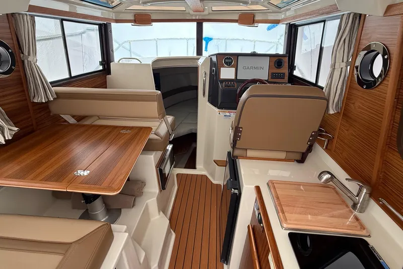 Slide: The Image of Interior of 2025 Ranger Tugs R-25 boat with wood accents and modern amenities. - 29