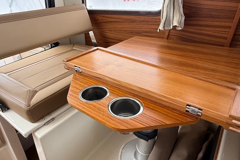 Slide: The Image of 2025 Ranger Tugs R-25 interior with wooden table and cup holders. - 32